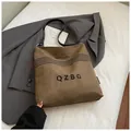 Brown bucket canvas bag with black letters and shoulder strap for casual styling - Brown