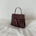 Chic dark brown faux suede handbag with a top handle and elegant golden metal buckle detail - Brown