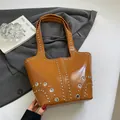 Polished brown leather tote bag with silver studs and sleek minimalist vintage aesthetic - Brown