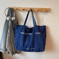 Grand sac cabas en denim bleu foncé avec logo blanc et texture en toile résistante - Bleu