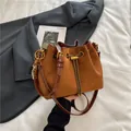 Brown suede drawstring bucket bag with gold chain accents and colorful bead charm - Brown with Pendant