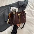 Deep brown matte suede bucket bag with gold chain drawstring and beaded pendant charm - Coffee With Pendant
