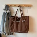 Sac fourre-tout en toile marron foncé avec imprimé Low Classic suspendu à un cintre - Café