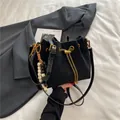 Minimalist black drawstring bucket bag with gold chain strap and wooden bead accessory - Black With Pendant