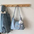 Minimalist light blue tote bag with star emblem and cloud pendant on white wall - Blue