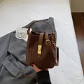 Brown woven texture bucket bag featuring a gold buckle and elegant top handle strap - Brown