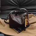 Vintage dark brown large capacity bucket bag with decorative wooden beads on a sofa - Coffee with Pendant