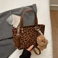Chic leopard print crossbody bag with brown leather handles and plush bear charm - Leopard Print With Charm
