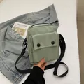 Mint green canvas crossbody bag with black adjustable strap and flap front pocket - Green