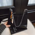 Borsa hobo nera patchwork con tracolla a catena argento e ciondolo in legno - nero con ciondolo