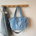 Large blue denim tote bag with adjustable shoulder strap and front flap pocket - Light Blue Large