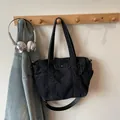 Minimalist deep black denim tote bag with adjustable shoulder strap and front flap pocket - Black Small