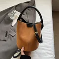 Caramel brown suede bucket bag with black leather handles and crossbody strap - Tan