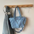 Light blue denim tote bag with front pocket and adjustable strap on a hook - Light Blue Small