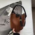 Brown faux suede bucket handbag with black leather handles and golden metal buckle - Brown