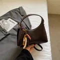 Retro dark brown crossbody bag in matte faux leather with vintage wooden bead charm - Brown