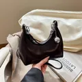 Deep brown glossy leather crescent shoulder bag with a large silver metallic ball charm - Brown