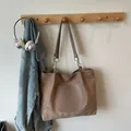Brown suede tote bag with leather pocket and chain strap in a lifestyle setting - Khaki