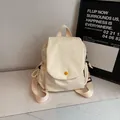 Cream white canvas backpack with a yellow button accent and flap closure design - Off White