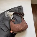 Stylish brown leopard print crescent shoulder bag with adjustable strap on gray blazer - Coffee