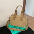 Macro view of khaki nylon travel bag showing durable handles and adjustable shoulder strap - Khaki