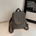 Minimalist grey canvas backpack with signature yellow buckle and flap closure - Gray