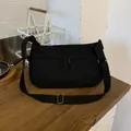 Close-up of black nylon messenger bag with wide adjustable strap and metal buckle - Black