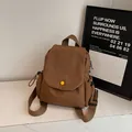 Brown canvas flip backpack with yellow button detail and side drawstring pockets - Brown