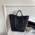 Black nylon tote bag with stylish black and white checkered woven handles and yellow tag - Black