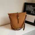 Braune Beuteltasche aus Wildleder mit goldenen Nieten und Schultergurt - Braun