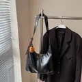 Retro black leather hobo bag with brown pompom and striped ribbon charm on metal hanger - Black With Pendant