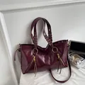 Deep burgundy leather tote bag with braided handles and golden metal rings - Burgundy