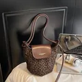 Bolso saco con estampado de leopardo, solapa de cuero marrón y correa de hombro - café