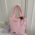 Detailed view of pink quilted tote bag with brown bow charm and brand logo tag - With Pendant / Pink