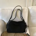 Minimalist black faux suede large tote bag with slim shoulder straps on a white sofa - Black