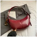 Dark red crescent shoulder bag with glossy finish and decorative wooden bead charm - With Pendant / Burgundy