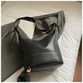 Minimalistische schwarze Leder-Eimertasche mit Hobo-Silhouette auf neutralem Hintergrund - Ohne Anhänger / Schwarz