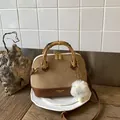 Detailed view of the leopard patchwork shell bag with bamboo handles and plush charm - Khaki With Pendant