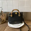 Borsa a conchiglia nera con manico in bambù naturale e finitura in ecopelle opaca - Nero senza ciondoli