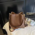 Borsa a secchiello marrone in pelle opaca con cuciture verticali e ampia tracolla in tessuto - caffè