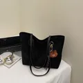 Minimalistische schwarze Tragetasche in Wildlederoptik mit braunem Bärenanhänger - Schwarz