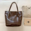 Deep brown oversized tote bag with premium leather texture and elegant metal ring charm - Brown with Pendant