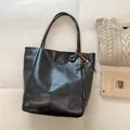 Minimalist large-capacity bucket bag in oily dark grey faux leather with a woven charm - Black With Pendant