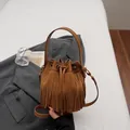 Elegante bolso bombonera de ante marrón con flecos largos y cierre de cordón ajustable - Marrón