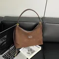 Dark coffee suede hobo bag with adjustable strap and golden hardware on leather sofa - Coffee without Pendant