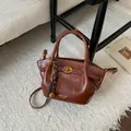 Elegante bolso tote de cuero marrón con cierre giratorio y accesorio trenzado - Marrón