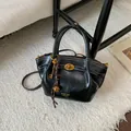 Bolso tote de cuero negro con herrajes dorados y detalles de costuras blancas - Negro