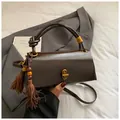 Retro dark brown underarm bag with decorative tassel and golden twist lock closure - With Charm / Brown