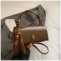 Minimalist deep brown glossy leather underarm bag with decorative tassel and metal lock - With Charm / Brown