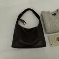 Détail du sac hobo en cuir marron foncé avec pompon en perles de bois et gaufrage - Avec Pendentif / Noir